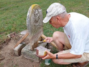 Dr. Bruce Warwick, right, founder of the Chatham-Kent Cemetery Restoration Project, uses a limestone mortar to repair a marble headstone in Chatham's Maple Leaf Cemetery on Wednesday.  (Ellwood Shreve/Chatham Daily News)