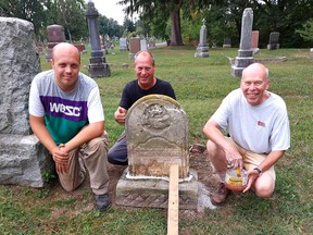 Dr. Bruce Warwick, right, founder of the Chatham-Kent Cemetery Restoration Project, is seen here with Tom Klaasen, middle, owner of Memorial Restorations, and his son Ethan Klaasen, by a marble headstone in Chatham's Maple Leaf Cemetery that was repaired by Warwick on Wednesday.  (Ellwood Shreve/Chatham Daily News)