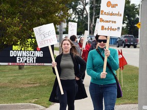 Kennedy Newton, a personal support worker at Chatham Retirement Resort, left, and Autumn Desormeaux-Malm, a nurse at the Keil Drive facility, participate in a rally against a cut in hours on Thursday. (Tom Morrison/Postmedia Network)