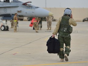 A Royal Canadian Armed Forces CF-18 Hornet fighter jet pilot from 4 Wing Cold Lake, Alberta walks down the flight line in Kuwait after his first combat mission over Iraq in support of Operation IMPACT on October 30, 2014. Photo: Canadian Forces Combat Camera, DND ORG XMIT: IS2014-5022 ORG XMIT: POS1610201843439698