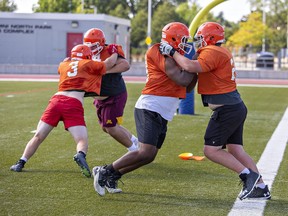 North Park Collegiate Trojans linemen (left to right) Quin Cassidy, Tyler Green, Tamarley Smith and Steven Rooney run a play during a recent senior football practice. The unit was key on Thursday in North Park's season-opening 7-3 win against Assumption College. Brian Thompson/Brantford Expositor/