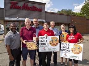 Local owners of Tim Hortons stores (front row, from left) Orville Bernard, Ron Fox, Ken Molloy, and QSR Group director of operations Mike Marquis (rear, center) join Richard Leadbetter and Gisele Budgell of Brant Food for Thought, and Angee Turnbull (right) of Lansdowne Children's Center Foundation as they prepare for the Smile Cookie campaign that runs Sept. 19 to 25.