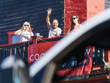 Eric Ruttle waves toward floats on the street at the labour day parade in Cochrane on Monday, Sept. 5, 2022.