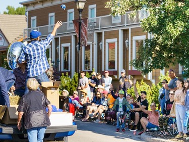 A man throws a football into the crowd at the labour day parade in Cochrane on Monday, Sept. 5, 2022.