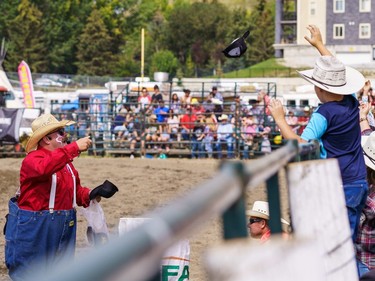 An entertainer throws hats into the crowd at the Lions Club rodeo in Cochrane on Monday, Sept. 5, 2022.