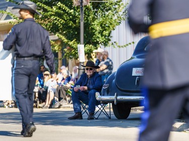 A spectator watches floats at the labour day parade in Cochrane on Monday, Sept. 5, 2022.