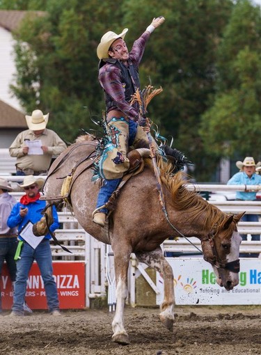 A boy hangs on to his horse during saddle bronc riding at the Lions Club rodeo in Cochrane on Monday, Sept. 5, 2022.