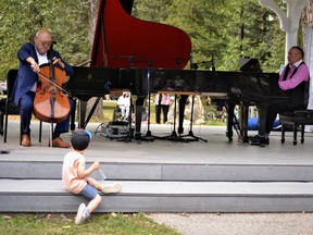 Over 600 people came to watch the free concert hosted by High River Gift of Music and produced by Honens Calgary. Darwin Craig (pictured), 3 1/2 years-old, was so mesmerized by cellist Arnold Choi and pianist Jon Kimura Parker that he sat at the corner of the bandstand stage with his bag of snacks. Photo by Dana Zielke
