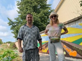 Will Bilow and Kelsey Tucker stand in the community garden that is serving as a group therapy setting for clients at Addictions and Mental Health Services – Kingston, Frontenac, Lennox and Addington.