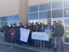 The Brothers in Arms Veterans Motorcycle Club presents Dawn House with a cheque for $12,785 outside the Red House West restaurant on Thursday.