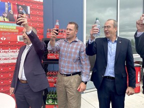 Kingston Mayor Bryan Paterson, from left, Pittsburgh District Coun. Ryan Boehme and Coke Canada Bottling president and chief operating officer Stephen du Toit toast the opening of the Coca-Cola distribution plant on Innovation Drive in Kingston's east end business park on Wednesday, Sept. 21, 2022.