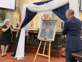 Kingston Mayor Bryan Paterson and Sharon Monson, wife of former mayor Harvey Rosen, unveil Rosen's portrait by artist Daniel Hughes in city council chambers in Kingston City Hall on Thursday.