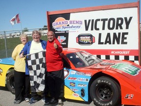 John Klages, centre, a resident at Queensway Long Term Care and Retirement Community in Hensall, recently had his dream come true when he was able to ride in a race car at Grand Bend Speedway. With Klages on Wed., Sept. 7 are his wife Janice, left, and Speedway co-owner Gord Bennett, right, who drove Klages 10 laps around the track.