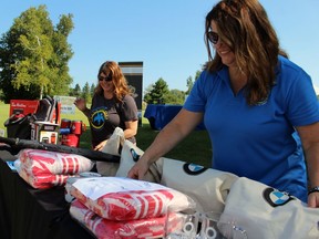 Alison Morrison, Pathways Health Center for Children's executive director, and communications lead Julie Ingles set up the prize table during the Sarnia Sting's fundraising golf tournament on Saturday at Huron Oaks Golf Course in Bright's Grove.  Terry Bridge/Sarnia Observer/Postmedia Network