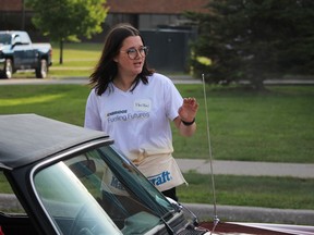 Volunteer Payton Morreau helps direct entries to Saturday's car show hosted by the company in Sarnia to raise money for the United Way of Sarnia-Lambton.