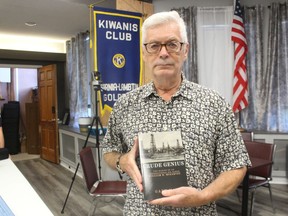 Writer Gary May holds his latest book, Crude Genius, while attending a meeting of the Kiwanis Club of Sarnia-Lambton Golden K, where he was a guest speaker.