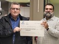 Martin Boucher, NISA's executive director, receives a cheque for more than $59,000 from Ken Porter, national program manager for the Mood Disorders Society of Canada, during a ceremony Thursday. The 9th Annual Defeat Depression event held on May 28 in Bell Park raised they money. Supplied