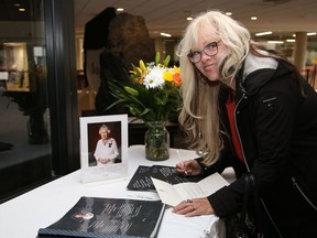 Sharon Neville signs a book of condolences for Queen Elizabeth II at Tom Davies Square in Sudbury, Ont. on Tuesday September 13, 2022. John Lappa/Sudbury Star/Postmedia Network