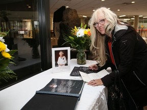 Sharon Neville signs a book of condolences for Queen Elizabeth II at Tom Davies Square in Sudbury, Ont. on Tuesday September 13, 2022. The book will be available for signing in the main foyer of Tom Davies Square during regular business hours until 4:30 p.m. on September 23, 2022. A release from the city said, "All messages received will be sent to the Royal Family on behalf of the community. Residents can also sign the national online book of condolences at www.canada.ca/en/canadian-heritage/commemoration-her-majesty-the-queen/book.html." John Lappa/Sudbury Star/Postmedia Network