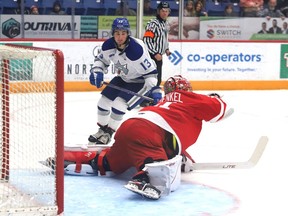 Kocha Delic, right, of the Sudbury Wolves, fires the puck at Charlie Schenkel, of the Soo Greyhounds, during OHL exhibition action at the Sudbury Community Arena in Sudbury, Ont. on Friday September 23, 2022. John Lappa/Sudbury Star/Postmedia Network