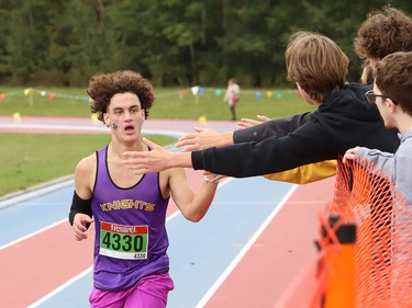 Callum Wiss, of Lo-Ellen Knights, receives high fives as he races to the finish line in the boys novice category at the 2022 Laurentian University Rumble on the Rock High School Cross-Country Meet at Laurentian University in Sudbury, Ont. on Tuesday September 27, 2022. About 400 competitors from Northern Ontario took part. John Lappa/Sudbury Star/Postmedia Network