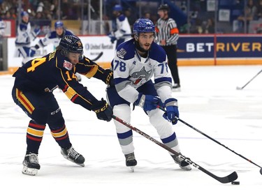 Andre Anania, right, of the Sudbury Wolves, and Ian Lemieux, of the Barrie Colts, battle for the puck during OHL action at the Sudbury Community Arena in Sudbury, Ont. on Friday September 30, 2022. John Lappa/Sudbury Star/Postmedia Network