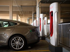 In this file photo, a Tesla Inc. electric vehicle charges at a supercharger station in Redondo Beach, California. Tesla officials have scouted Sudbury as a possible home for a factory that would build electric batteries or battery materials, Electric Autonomy Canada reports. PATRICK T. FALLON/AFP via Getty Images
