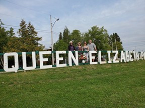 Although Cochrane is thousands of miles away from London, the death of Queen Elizabeth II was felt in the community. Roxanne DesRoches, her mother Gaetanne Mayer-Powell, father Robert Dale Powell, and aunt Blandine Mayer-Courville took the suggestion of cousin Celeste Courville to honour the Queen and placed a large floral arrangement at the sign of Queen Elizabeth Park. Times-Post photo by Debbie Morin