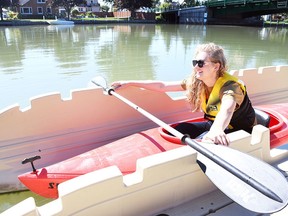 Kelsey Nydam, executive director of the Downtown Wallaceburg BIA, uses the kayak launcher near Civic Square Park Sept. 1, 2022. (Tom Morrison/Chatham This Week)