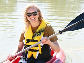 Kelsey Nydam, executive director of the Downtown Wallaceburg BIA, takes one of the kayaks from the new Whimsies Paddle Adventure rental service onto the Sydenham River Sept. 1, 2022. (Tom Morrison/Chatham This Week)