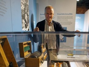 Elgin County Museum curator Mike Baker looks over a Second World War Enigma machine with which Germany coded and decoded military secrets. ItÕs part of a new exhibition at the museum. (Eric Bunnell/Special to Postmedia Network)