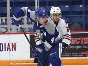 Jacob Holmes, front, of the Sudbury Wolves, attempts to tip a shot towards the goal during OHL action against the Niagara IceDogs at the Sudbury Community Arena in Sudbury, Ont. on Friday February 11, 2022.