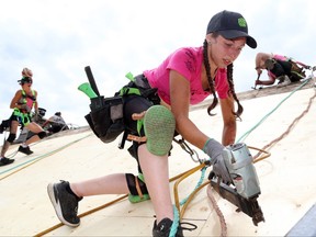 Ottawa roofer Vanessa Sukkar secures plywood while replacing the roof of a home on June 30, 2022 in Plainfield, Ont., north of Belleville.