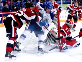 Alex Assadourian (9) of the Sudbury Wolves battles for position with Matthew Mayich (22) of the Ottawa 67's in front of 67's goaltender Max Donoso (35) during OHL action at Sudbury Community Arena on Sunday, October 23, 2022.