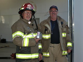 Powassan firefighter Ron Reynolds, left, displays his 30-year provincial service medal.  Fire Chief Bill Cox, right, handed out the provincial and federal awards that recognize long service with the volunteer department.