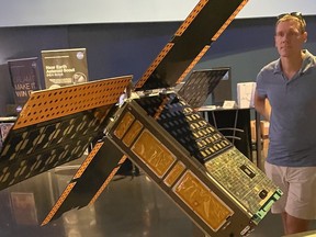 Chris Thome of NOSM University examines a 6U CubeSat spaceship at NASA Kennedy Space Center that will be on board the Artemis I rocket, carrying yeast samples to gauge the impact of cosmic radiation on cells.