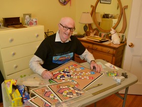Stratford's James Colbeck, a retired teacher, has used an old student project featuring the outline of a hand to design and develop a new board game he's calling Digits. Pictured, Colbeck packages his game for distribution at his work station in his home in Stratford. Galen Simmons/The Beacon Herald/Postmedia Network