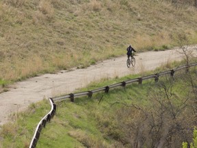 A  cyclist gets in a mid-morning workout on a Saturday in May as he pedals up an old section of road near the Twelve Foot Davis Gravesite near Peace River. PHOTO RANDY VANDERVEEN
