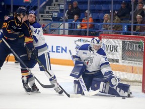 Sudbury Wolves goaltender Joe Ranger (29) makes a pad save while Wolves forward Ethan Larmand (45) looks to hold off Barrie Colts forward Cole Beaudoin (29) during first-period OHL action at Sudbury Community Arena in Sudbury, Ontario on Friday, October 14, 2022.