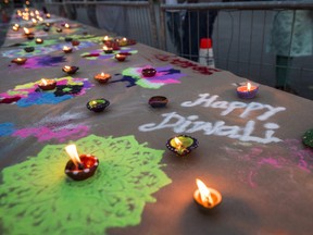 Rows of lit candles sit alongside chalk drawings as Belleville residents and members of the Indian community celebrate Diwali on Sunday in Belleville, Ontario. ALEX FILIPE