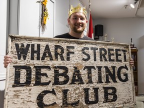 Coun. candidate Tyler Allsopp holds the sign for the Wharf Street Debating Club Bun Feed after being crowned its winner on Friday in Belleville, Ontario. ALEX FILIPE