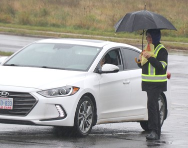 Pamphlets are distributed in the rain before a rosary rally at Our Lady of Fatima grotto at Our Lady of Good Counsel Catholic Church in Sault Ste. Marie, Ont., on Saturday, Oct. 15, 2022. (BRIAN KELLY/THE SAULT STAR/POSTMEDIA NETWORK)