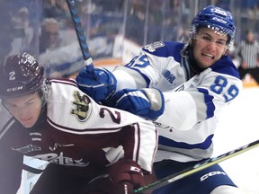 Sodbury Wolves forward Nathan Villeneuve (89) lays a hit on Peterborough Petes defenceman Samuel Mayer (2) during OHL action at Sudbury Community Arena in Sudbury, Ontario on Sunday, October 16, 2022.
