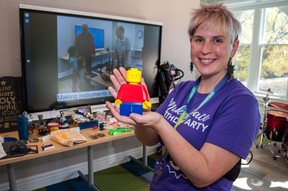 Librarian Liz Anderson holds a 3D-printed Lego figure in front of a showcase of community projects created in the Stratford public library's MakerSpace.  The library recently celebrated the MakerSpace's fifth anniversary.  Chris Montanini/Stratford Beacon herald