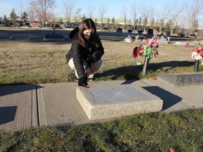 École Leduc Junior High School student Cassidy Tremblay lays a poppy on a headstone at the Leduc Municipal Cemetery Nov. 2. (Ted Murphy)