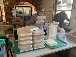Containers filled with turkey and all of the fixings are bagged and distributed through Martha's Table's takeout window Monday afternoon. Peter Hendra/The Kingston Whig-Standard