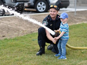 Ivan McDougall, 3, had his chance to spray water at a target with the help of West Perth firefighter Chris McKone during the West Perth Fire Department (WPFD) open house Oct. 11, part of their annual Fire Prevention Week festivities. Plenty of youngsters had the same chance but also, more importantly, learn how to prevent fires in their homes. ANDY BADER/MITCHELL ADVOCATE