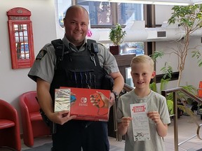 Officer Kurtis Taylor, GPES, left, and  Dalien Wiebe. Wiebe was the winner of the Positive Ticket Program for 2022 and took home a Nintendo Switch and game.