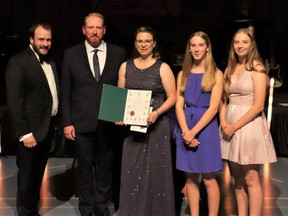 Airdrie Health Foundation chair Ryan Thompson (from left to right), founders Jeff and Michelle Bates, and their two daughters accept the Queen Elizabeth II Platinum Jubilee Coin during the organization's Light Up the Night Gala on Sept. 24, 2022.