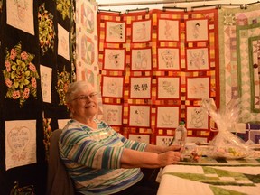 Helen Murphy, the Airdrie and District Quilt Guild's Quilter of Distinction, sits among some of her quilts which she had displayed at the Balzac Community Hall on October 15. Murphy has created over 100 quilts by hand.